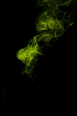 delicate yellow smoke on black backgroundの写真素材