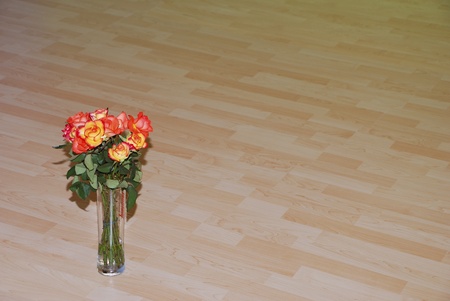 bouquet of fresh roses in a vase on a beautiful wood flooringの写真素材