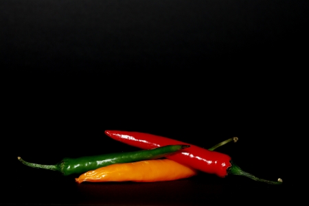 colorful chilli pepper on black backgroundの写真素材