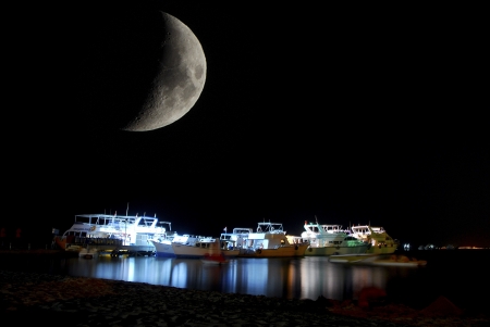 illuminated boats on the beach at nightの写真素材