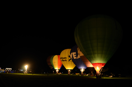 many colorful balloons on a yellow fire in the nightのeditorial素材