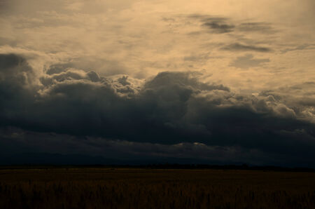dark clouds with thunderstorm and field in summer