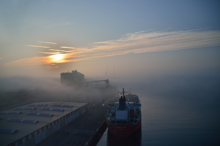 ship in harbor with fog and sunのeditorial素材