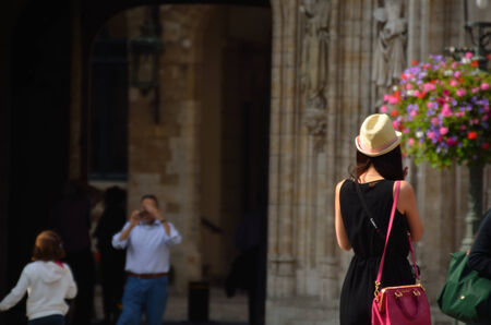 young woman with hat and bag is in the cityの写真素材