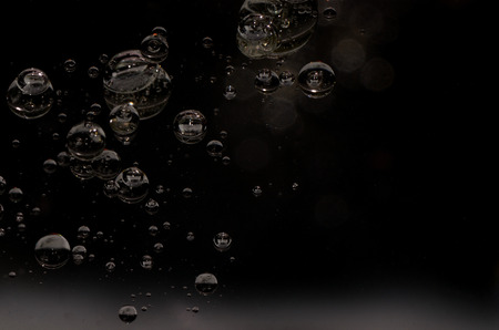 oil droplets in water on black surface