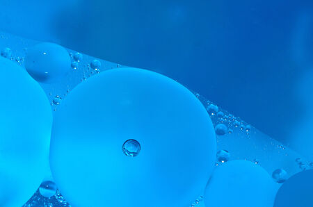 oil structures on blue water surfaceの写真素材