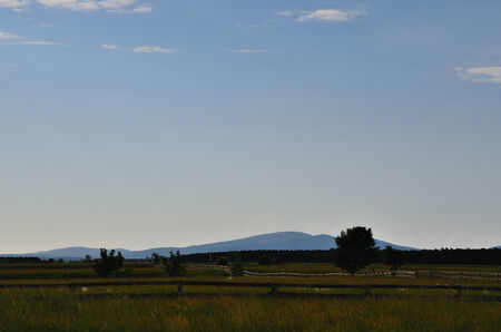 landscape with mountain meadow and fenceの写真素材