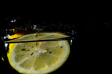fresh yellow lemon drops below water surfaceの写真素材
