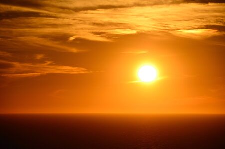 warm bright orange sunset by the seaの写真素材