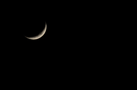 moon with thin crescent in the night black backgroundの写真素材