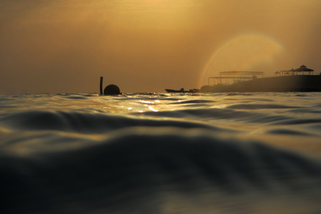 diving and snorkeling in the sea at sunriseの写真素材