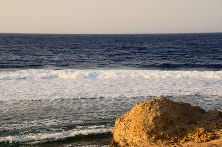 sand beach with waves and far horizon on the seaの写真素材