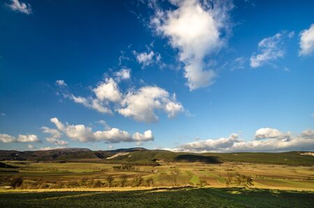 green mountains and white clouds in a blue skyの写真素材