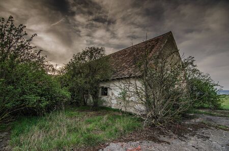 old house with dark rain cloudsの写真素材