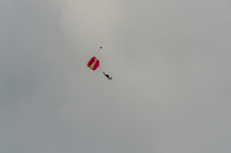 parachute jumpers hovering on gray sky