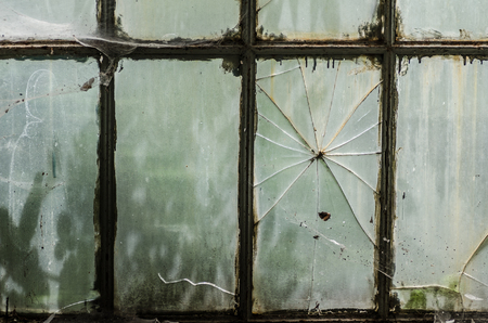 old window with crack in the glassの写真素材