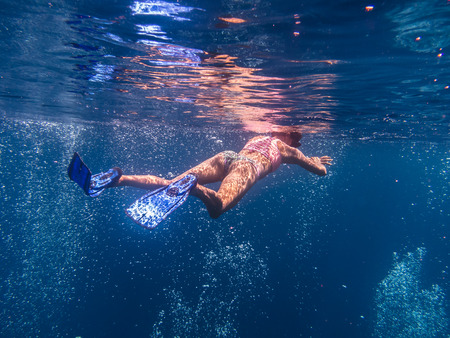 woman snorkeling in many bubbles of diverの写真素材