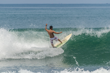 man surfing on a wave on vacation in Baliの写真素材