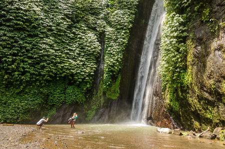 waterfall gitgit in the jungle in bali with touristsの写真素材