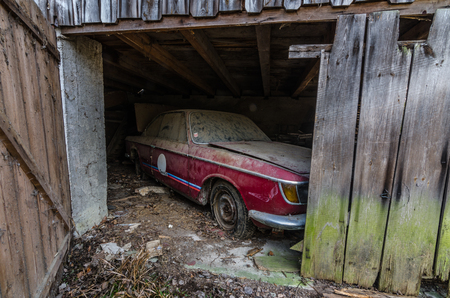 red car in abandoned wood stall of farmの写真素材