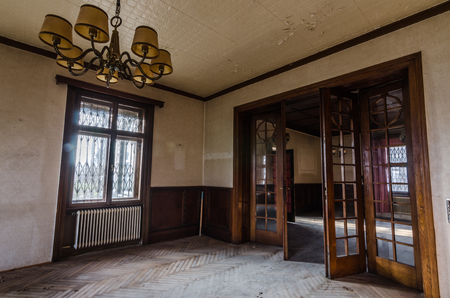 lamp and big wooden door in anteroom of abandoned houseの写真素材
