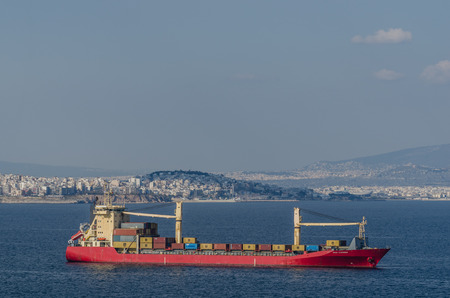 container ship and city athens by the sea