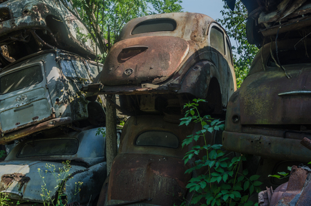Old rusty cars on a junkyardの写真素材