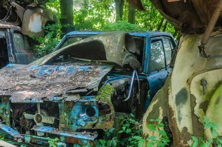 Blue car on junkyard near a forestの写真素材