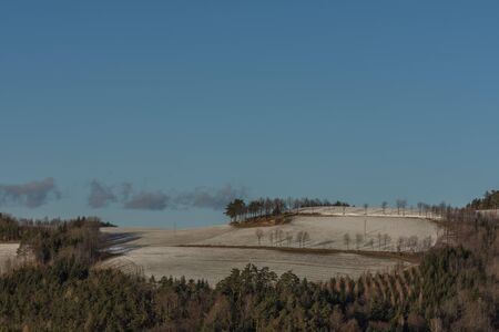 hilly landscape and layer of snow in winterの写真素材