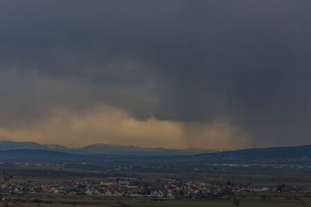Landscape with houses and storm clouds in the skyの写真素材