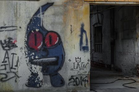 Wall with figure graffiti in a factoryの写真素材