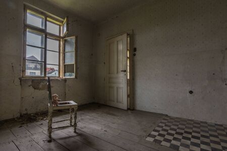 Armchair with teddy bear in a room of a houseの写真素材