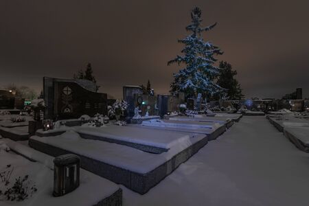 Lights and snow at the cemetery in winterの写真素材