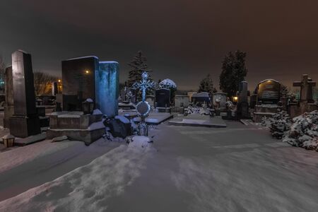 snow and grave with cross of iron in a cemeteryの写真素材