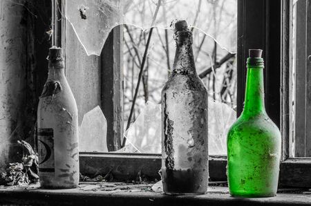 Single green bottle near a window in old house with gray backgroundの写真素材