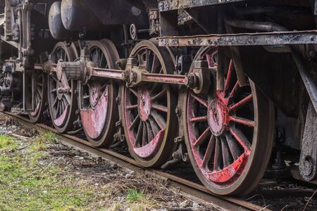 Red wheels with different counterweights of an old locomotiveの写真素材