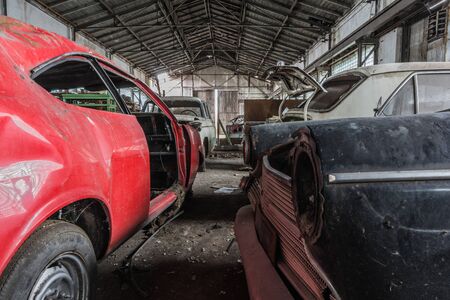 disassembled old cars in a large abandoned hallの写真素材