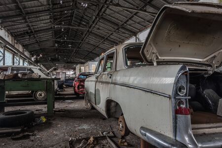 old car with open trunk in a large abandoned hallの写真素材