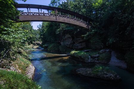 wooden bridge over a brook in the woods while hiking in the summer