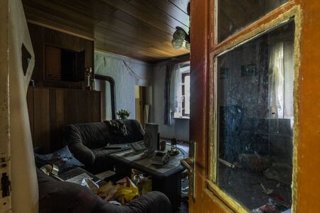 open door with a view of a dark living room with many objectsの写真素材