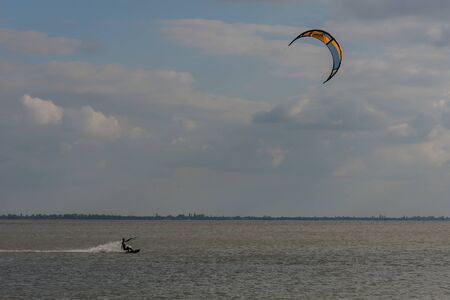 Autumn kite surfing on a lake with blue sky and cloudsの写真素材
