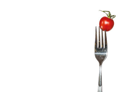 tomato on a fork with white backgroundの写真素材