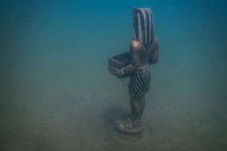 egyptiian statue at the ground of a lake while diving in the mountainsの写真素材