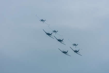many planes in formation at a air show with grey skyの写真素材