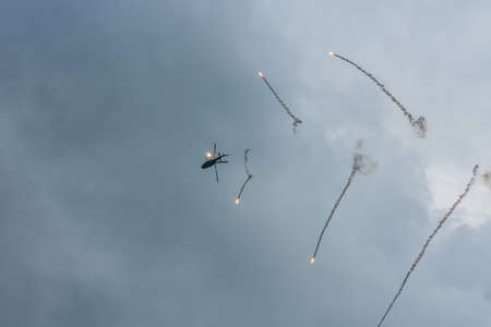 military helicopter with defensive measures on the skyの写真素材