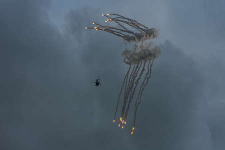 military helicopter with defensive measures and storm clouds in the summerの写真素材