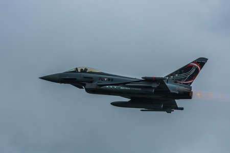 fighter plane fly at a air show large view with rain clouds