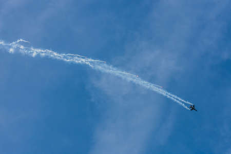 fighter plane flies down with defensive measures at a air show with blue sky