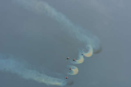 fumes of smoke and air swirls from a flight squadron at a air show during rain