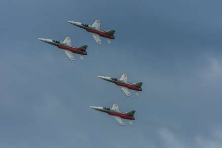 four planes flying in formation at a air show in the summer